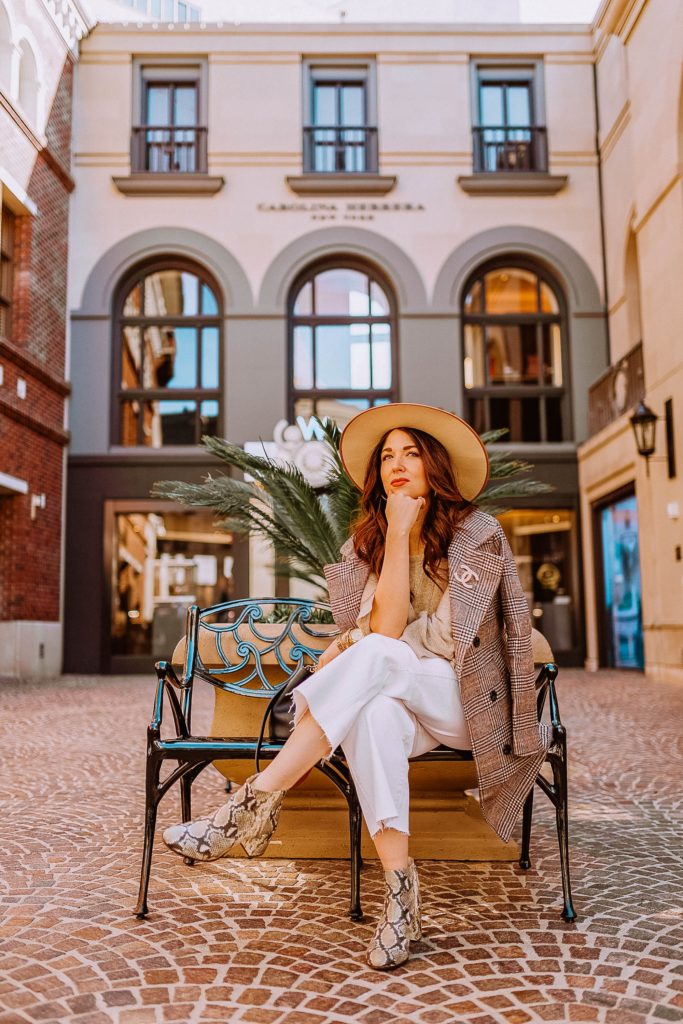 Girl wearing winter neutrals sitting on a bench