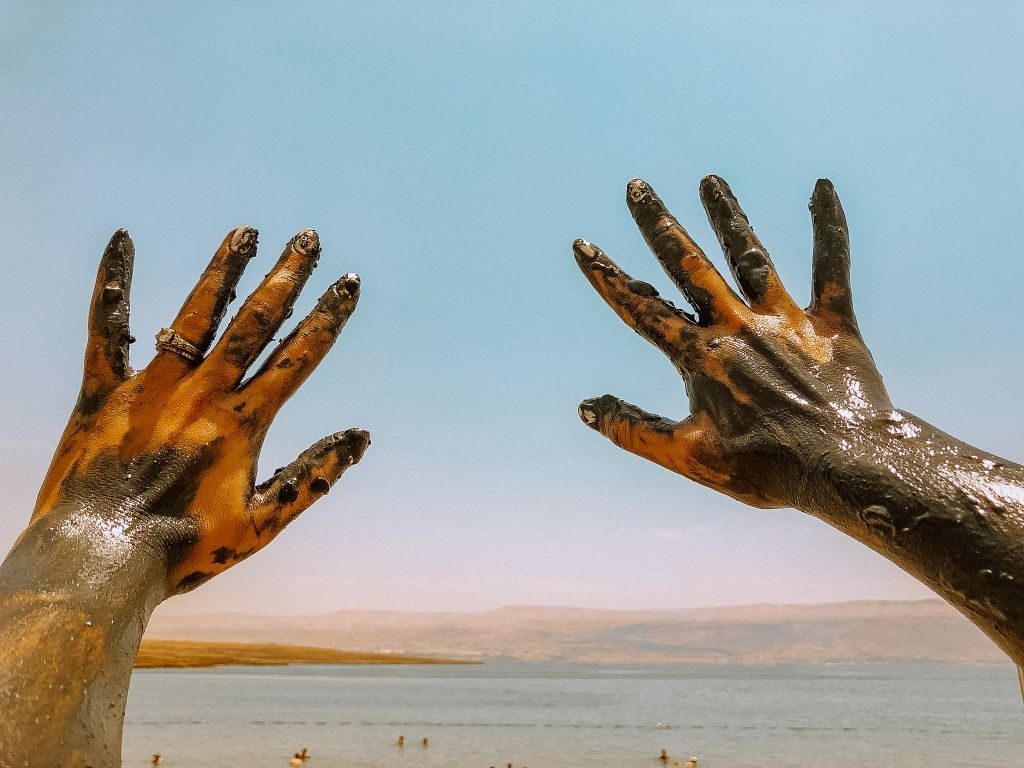 Dead Sea Mud covered hands at the Dead Sea in Israel