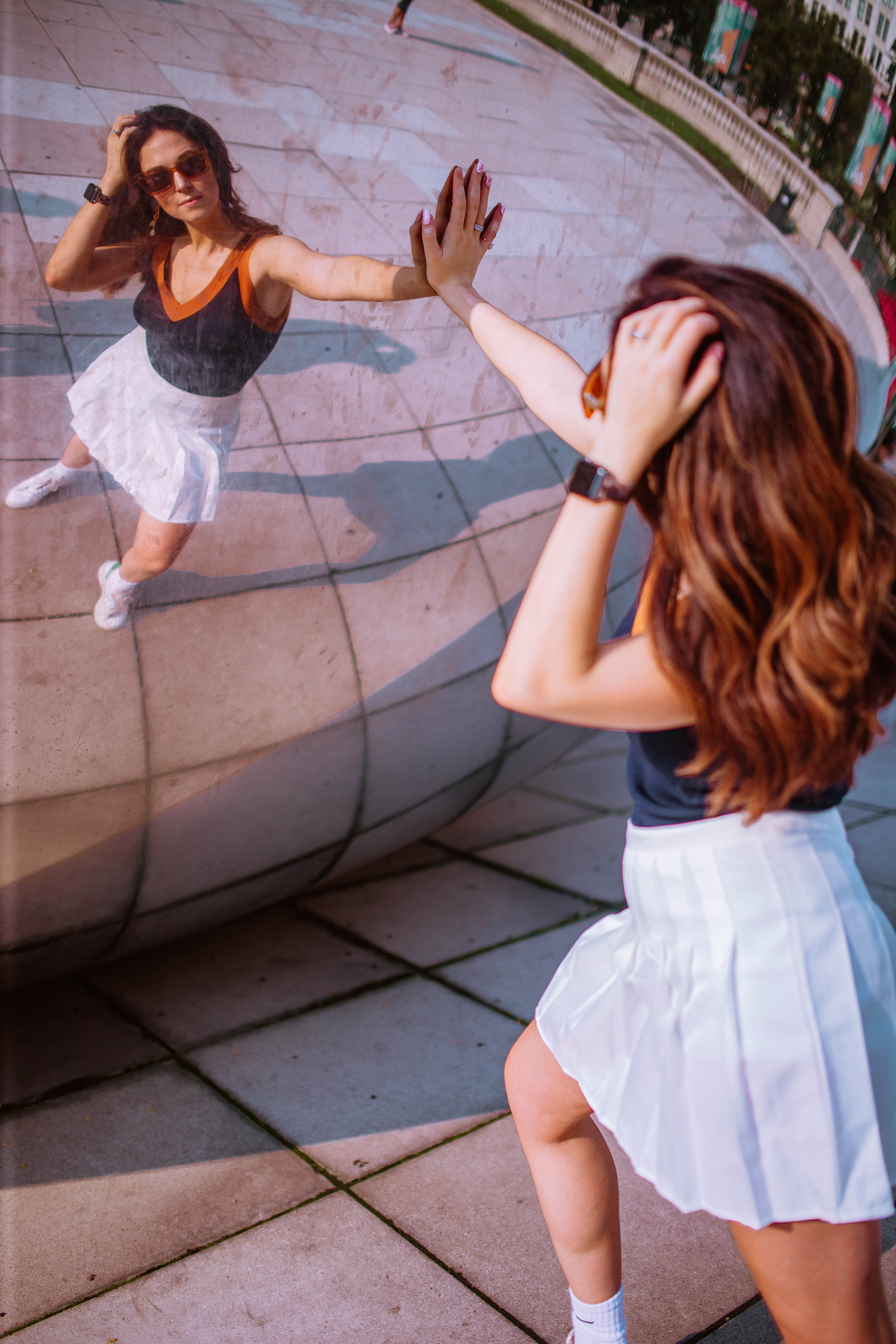 girl posing in reflection of the bean in millennium park, chicago