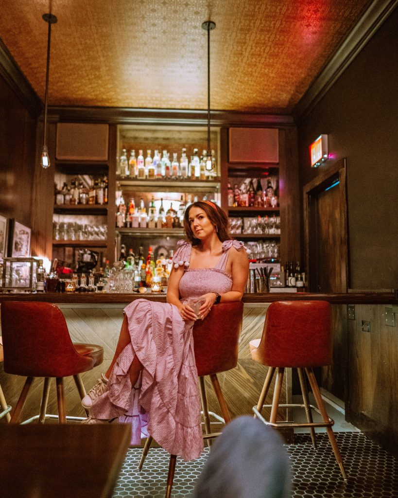 Girl sitting at the bar at the Alderman, the speakeasy inside of Pilsen Yard. One of Chicago's coolest speakeasy bars